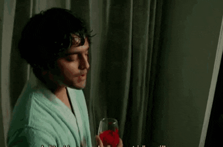 a man in a robe is holding a glass of wine