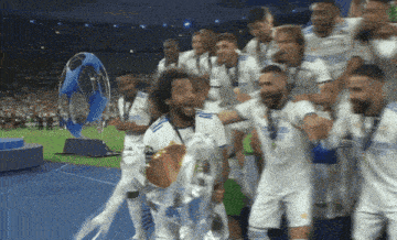 a group of soccer players are holding a trophy