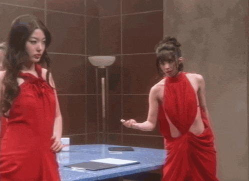 a woman in a red dress looks at the camera