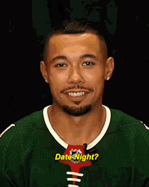 a man is wearing a green jersey that says date night on it