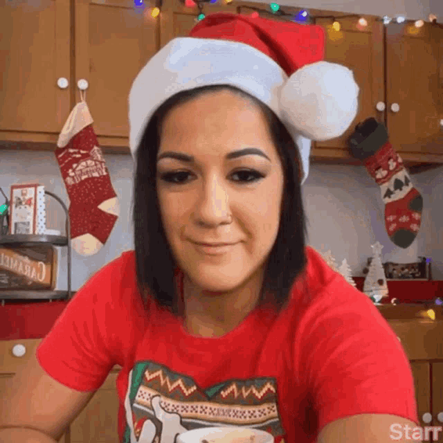a woman wearing a santa hat and a red shirt with the word starr on it