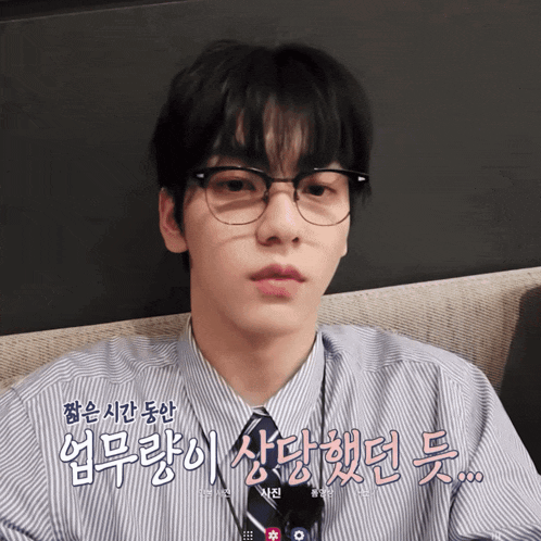 a man wearing glasses and a striped shirt with foreign writing on the bottom