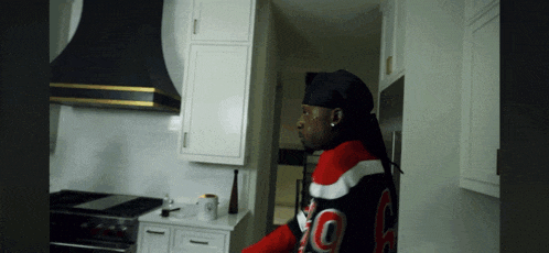 a man in a black and red sweater with the number 10 on the back