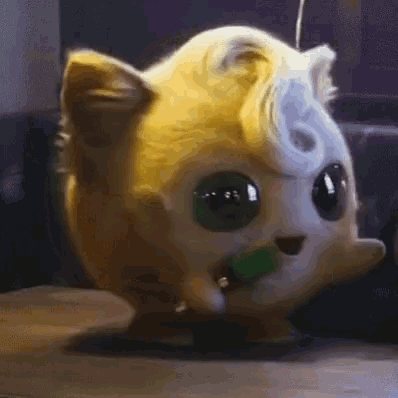 a close up of a stuffed animal that looks like a cat with green eyes .