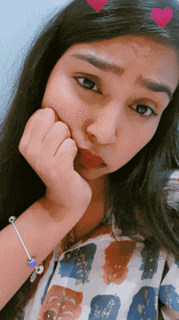a girl with a bracelet on her wrist has her hand on her face