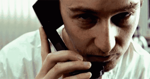 a man in a white shirt is talking on a cellphone
