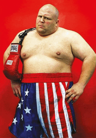 a man wearing everlast boxing gloves stands with his hands on his hips