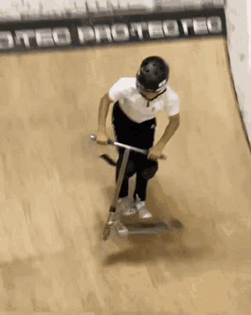 a person wearing a helmet and sunglasses is riding a scooter