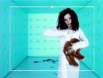 a woman in a white dress is holding a brown teddy bear