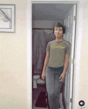 a man wearing a t-shirt that says mauirider is standing in a doorway