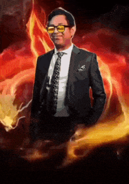 a man in a suit and tie stands in front of a fire background