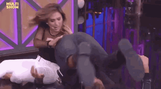 a woman is holding a man 's butt on a stage .