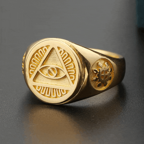 a gold ring with an eye in a triangle