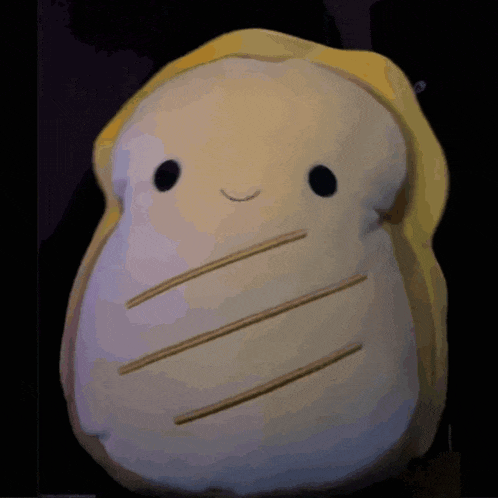 a stuffed animal in the shape of a sandwich with a smile on its face