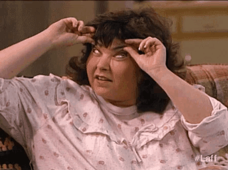 a woman is sitting on a couch with her eyes closed and her hands on her head .
