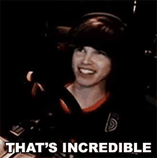 a man wearing headphones is smiling with the words that 's incredible above him .