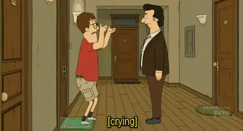 a man in a suit is standing next to a boy who is crying in a hallway .