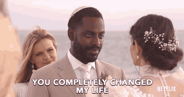 a man in a suit says " you completely changed my life " while standing next to a woman in a wedding dress