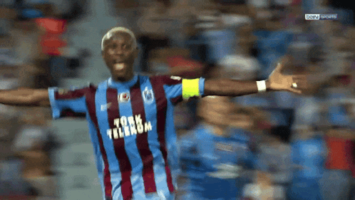 a soccer player wearing a blue and red striped shirt with turkm on it