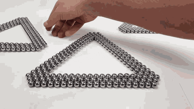 a person is playing with a triangle made of metal beads