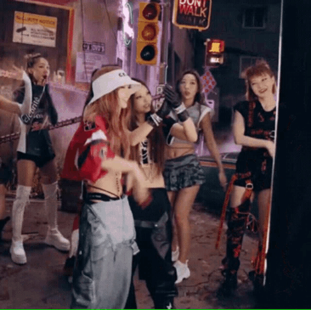 a group of girls are dancing in front of a sign that says don t walk
