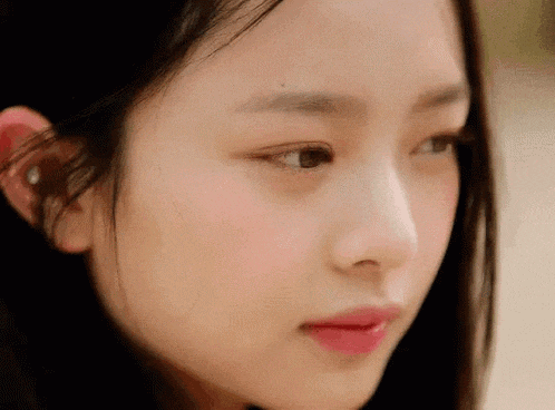 a close up of a woman 's face with a pink lip