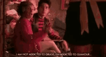 a man and a woman are sitting on a bed and the woman is talking about drugs .