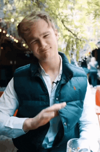 a man wearing a blue vest with a polo on it