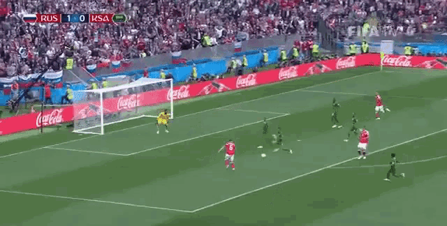 a soccer game is being played on a field with coca cola advertisements on the sidelines