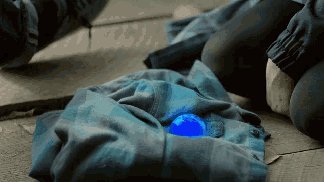 a person is laying on the floor with a blue ball in their pocket