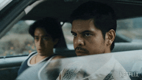 two men sitting in a car with netflix written on the bottom