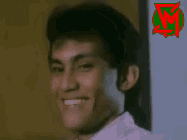 a close up of a man 's face with a green and red logo in the background