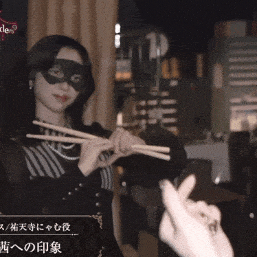 a woman wearing a mask is holding drum sticks