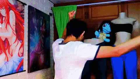 a man in a white shirt is standing in front of a display of anime posters