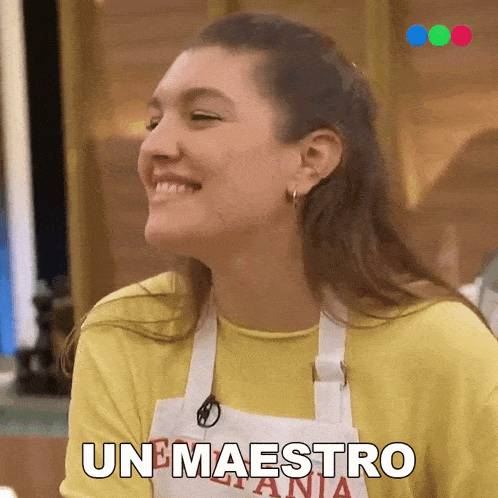 a woman wearing a yellow shirt and an apron is smiling and says unmaestro
