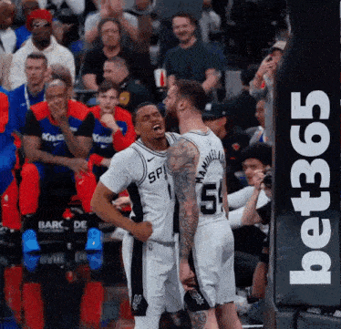a basketball player with the number 51 on his jersey stands next to another player