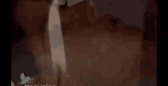 a close up of a person lighting a candle in the dark .