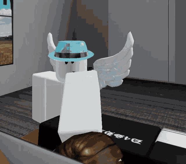 a roblox character wearing a blue hat and wings is sitting in front of a laptop