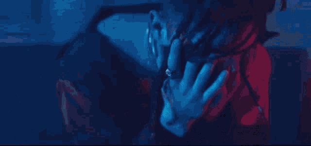 a close up of a person 's face with a red and blue light behind her .