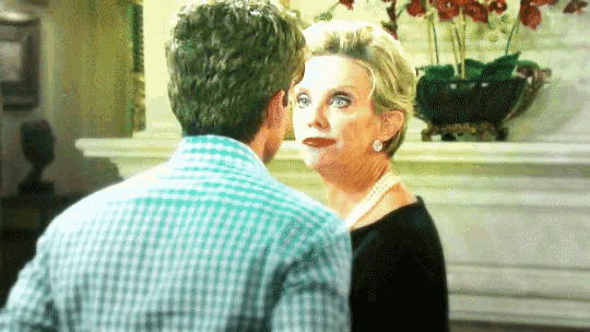 a man and a woman are standing next to each other and the woman is wearing a pearl necklace