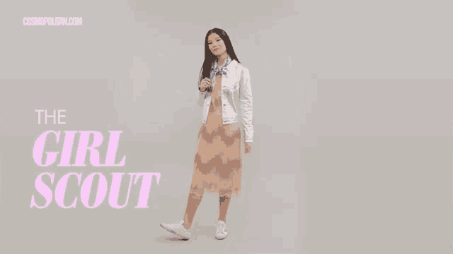 a woman in a dress is dancing in front of a cosmopolitan.com ad