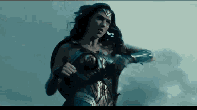 a woman in a wonder woman costume is standing in the rain .