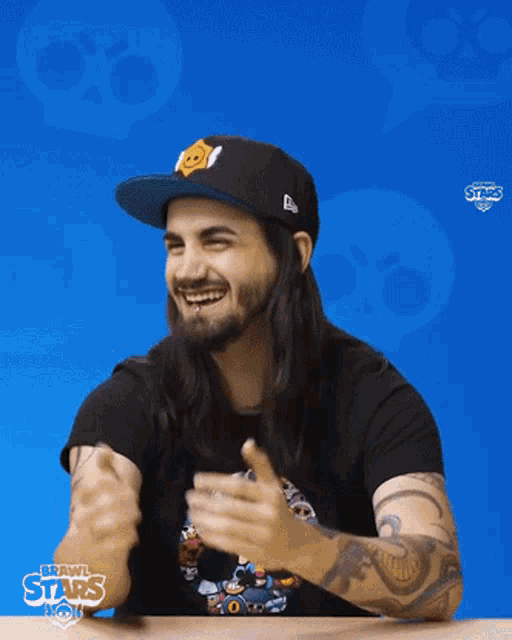 a man with long hair and a beard is wearing a brawl stars shirt