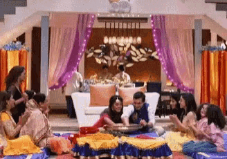 a group of people are sitting on the floor in a room decorated for a party .