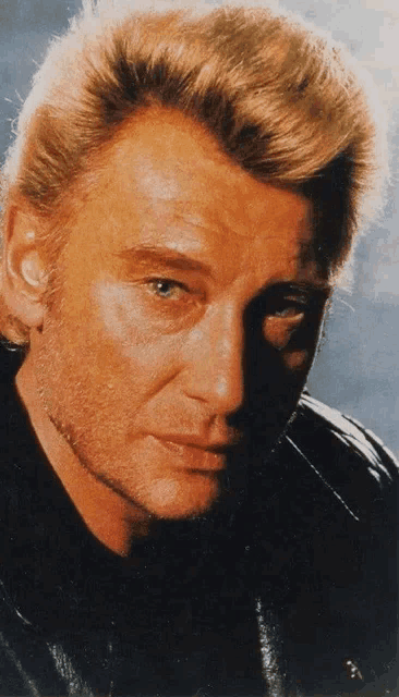 a close up of a man 's face with a black jacket