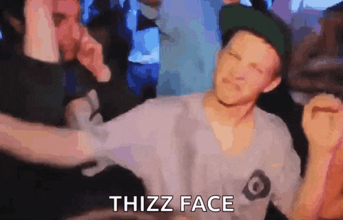 a man in a hat is being punched in the face by another man in a club .