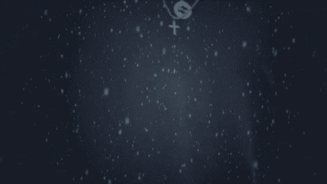a man wearing a black sweater and a cross necklace stands in the snow