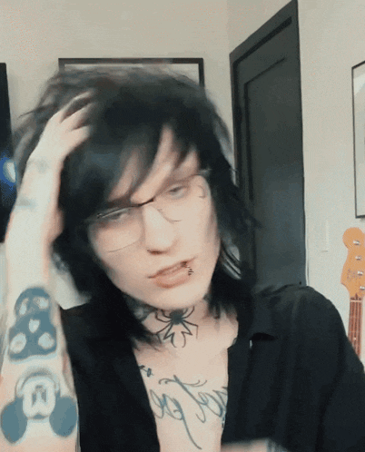 a person with glasses and a tattoo on their arm that says ' i love you '