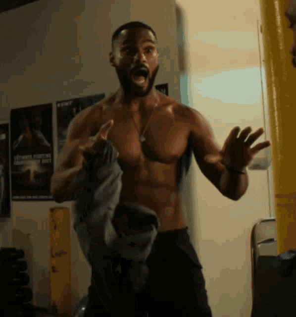a man without a shirt is standing in front of a poster for fight