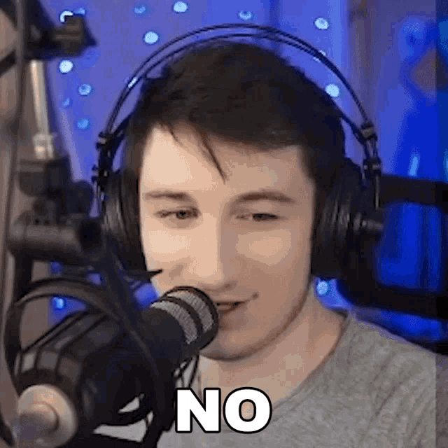 a man wearing headphones is talking into a microphone .